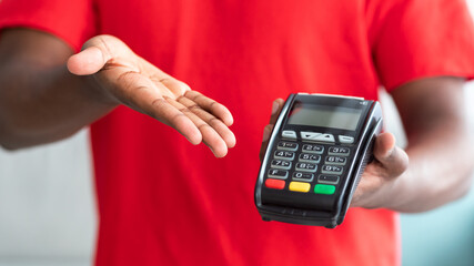 Cropped view of black man in uniform holding POS machine