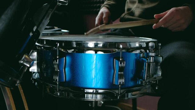 close up - the drummer plays with sticks on a snare drum, home lesson paradiddle training