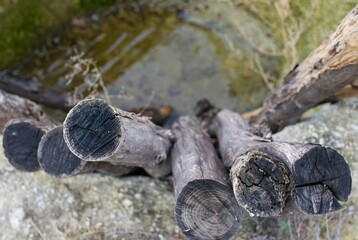 Close up of long round wooden beams in a pit