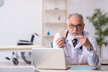 Old male doctor working at the hospital