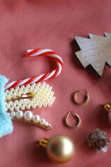 Pastel colored stocking filled with small presents and Christmas decorations. Pink background, selective focus.