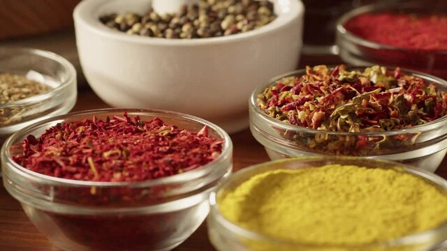 Various spices in glass bowls close-up. Middle eastern and arabian culture. Seasoning and flavors. Pepper, coriander, cinnamon, turmeric, paprika, cumin. Different kinds of dry herbs for cooking. 