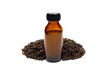 Black pepper essential oil in glass bottle with pile of peppercorn isolated on white background.