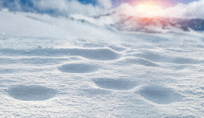 Fresh snow against the backdrop of a beautiful mountain landscape and the sun in the background 