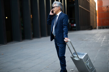 Senior businessman outdoors. Middle-aged businessman talking to the phone