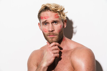 White shirtless man with lipstick marks looking at camera