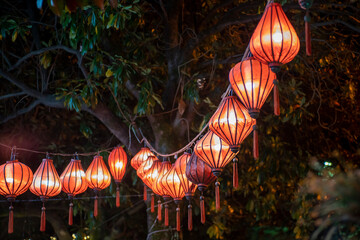 A row of Chinese orange lanterns in the street.