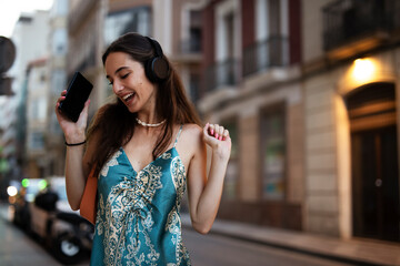 Beautiful young elegance woman using the phone. Beautiful fashion woman listening the music..