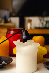 The tray with candles on a wooden table for a cozy hygge atmosphere. Christmas decor. Candle wick trimmer and snuffer. Interior decor in a modern room.