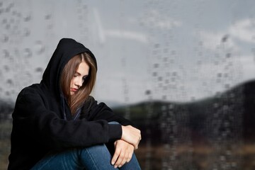 Young frustrated thoughtful woman looking out rainy window in distance alone, lost in thoughts, upset