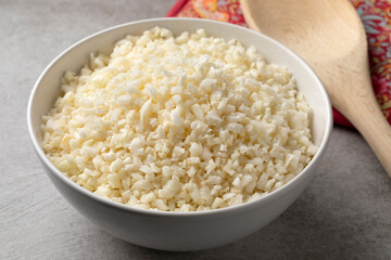 Bowl with fresh raw cut cauliflower rice close up
