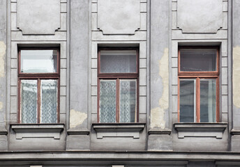 Fototapeta na wymiar Three Windows on the facade of the gray house
