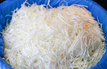A large volume of shredded cabbage for cooking.