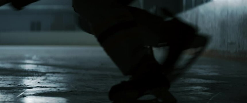 CU on skates, unrecognizable players entering ice rink before training. Shot on RED cinema camera with 2x anamorphic lens