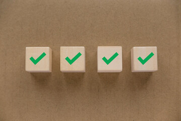 Green checkmark on a wooden cube. Checklist concept. © MohamadFaizal