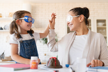DIY home project. Homeschooling concept. Mother and daughter making chemical experiment in...