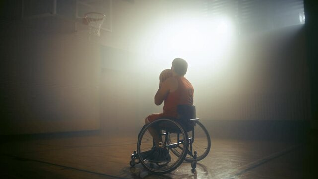 Wheelchair Basketball Player Wearing Red Uniform Shooting Ball Successfully, Scoring a Perfect Goal. Determination, Training, Inspiration of Person with Disability. Dolly Slow Motion with Warm Colors
