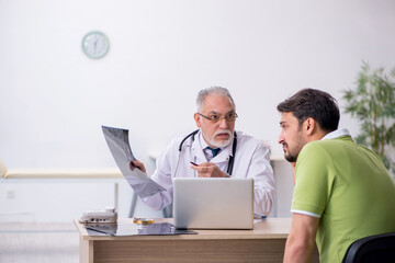 Young man visiting old male doctor radiologist