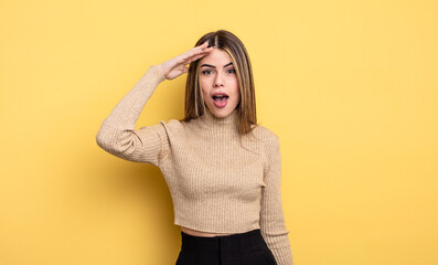 pretty caucasian woman looking happy, astonished and surprised, smiling and realizing amazing and...
