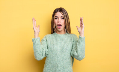 pretty caucasian woman looking shocked and astonished, with jaw dropped in surprise when realizing...