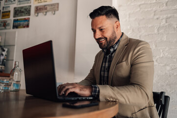 Businessman working on his laptop while drinking coffee in a cafe