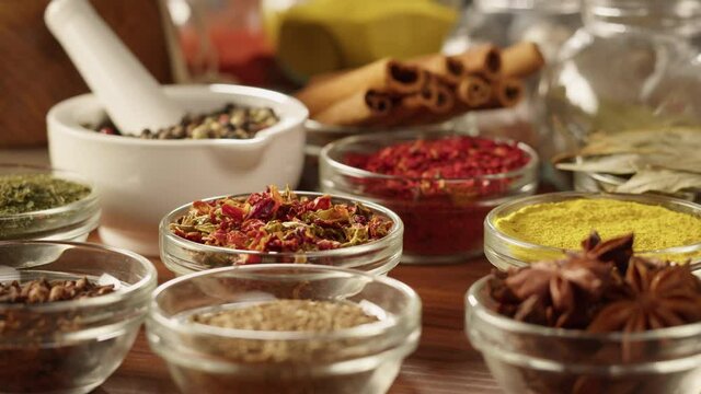 Colourful spices in glass bowls close-up. Middle eastern and arabian culture. Seasoning and flavors. Pepper, coriander, cinnamon, turmeric, paprika, cumin. Different kinds of dry herbs for cooking. 