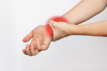 Close-up of a woman's hand holding a wrist in the other hand isolated on a white background. Wrist injuries, arm pain, carpal tunnel syndrome, neuralgia