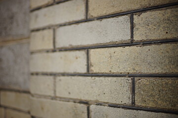 White brick wall with grey seams. Perspective close up view.