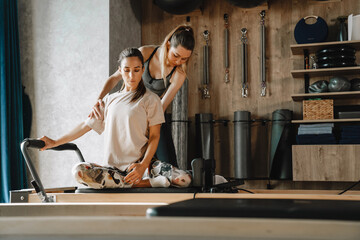 White woman working out on exercise machine during pilates class
