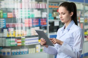 Pharmacy Drugstore: Beautiful Pharmacist Uses Digital Tablet Computer, Checks Inventory