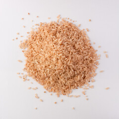 pile of whole grain brown rice isolated on white background, closeup view taken from above