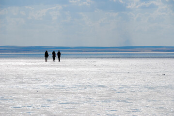 Tuz Lake, Turkey. Three people walking in the arid landscape. The second largest lake in Turkey. The area it covers is divided between the Turkish provinces of Ankara, Konya and Aksaray.
