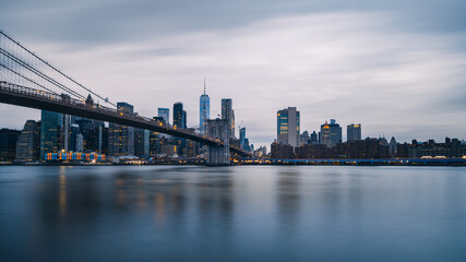 Panoramic, calm view of Brooklyn bridge and lower Manhattan, New York City at twilight