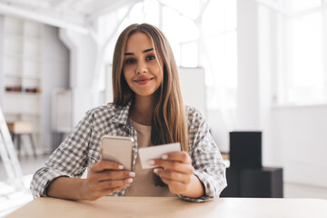Girl looking on business card and mobile phone