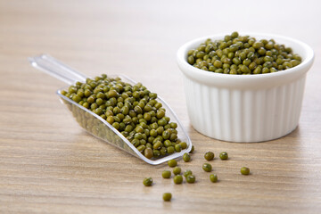 mung bean in wood spoon and white bowl on wood table
