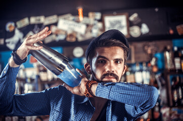 Focused barkeeper makes a cocktail at the night club