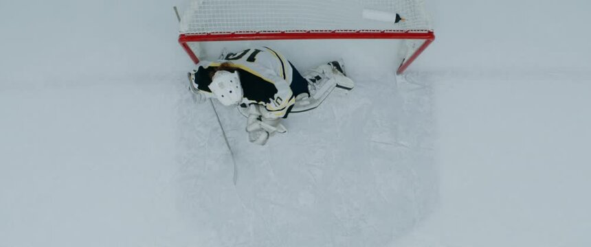 OVERHEAD HIGH ANGLE Goalie Warming Up In The Net Before The Hockey Game. Shot With 2x Anamorphic Lens