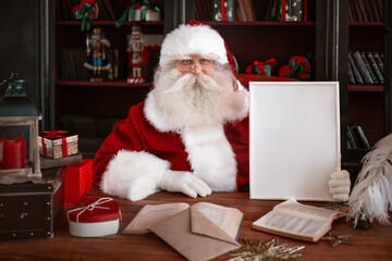 Obraz na płótnie Canvas Santa Claus holding white frame in his hands