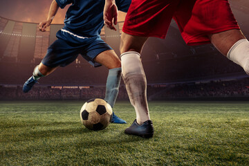 Two male soccer, football players dribbling ball at the stadium during sport match at crowed stadium. Sport concept