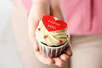 Girl holding heart shaped cake with the inscription I Love You. Cupcake in the shape of Heart,...