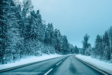 Winter asphalt road.  Winter road and trees with snow and Latvian landscape. Soft focus on photos.