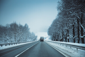 Winter asphalt road.  Winter road and trees with snow and Latvian landscape. Soft focus on photos.
