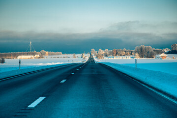 Winter asphalt road.  Winter road and trees with snow and Latvian landscape. Soft focus on photos.