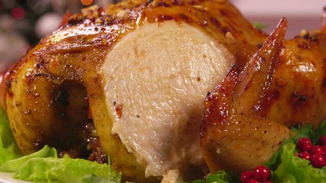 Super close-up of delicious baked Christmas chicken cut with the knife