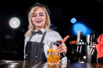 Girl bartender mixes a cocktail on the brasserie