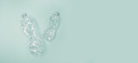 Used rumpled plastic bottles on a green background. Ecology problem. Top view. Copy space.