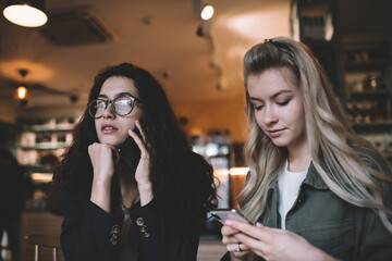 Young women with smartphones in cafe