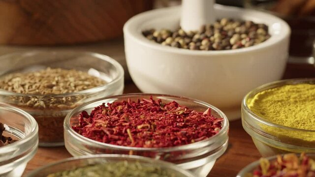 Various spices in glass bowls close-up. Middle eastern and arabian culture. Seasoning and flavors. Pepper, coriander, vanilla, turmeric, paprika, cumin. Different kinds of dry herbs for cooking. 