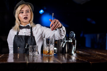 Girl bartender mixes a cocktail on the public house