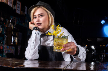 Girl bartender creates a cocktail in the pothouse
